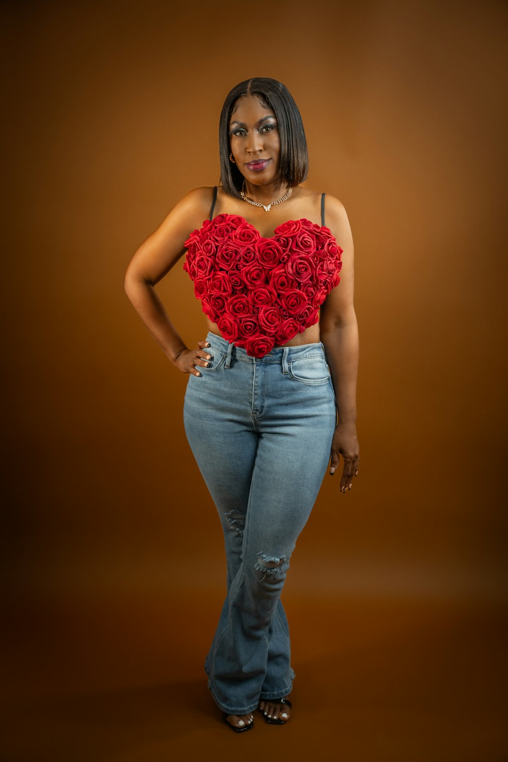 a woman wearing jeans and a red rose heart top
