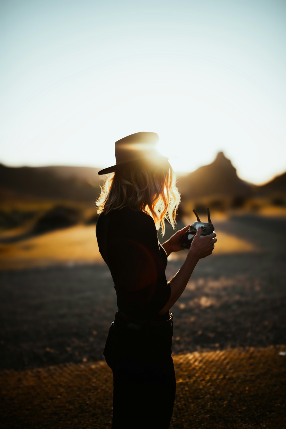 a woman standing on a road holding a cell phone