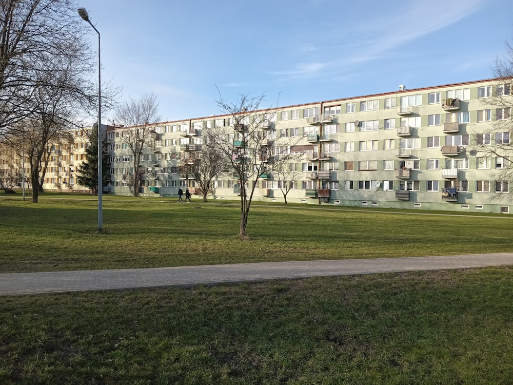 a grassy area in front of an apartment building