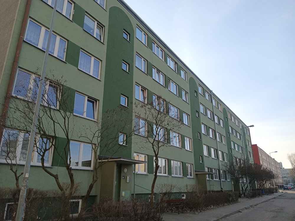 a green building with lots of windows on the side of it