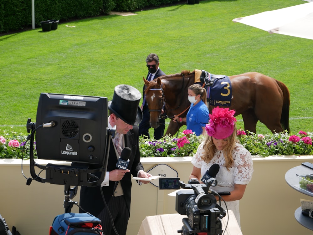 a man in a top hat and a woman in a white dress and a horse