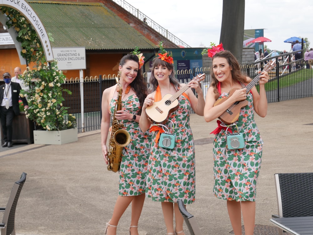 a group of women standing next to each other holding guitars