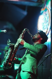 a man in a green suit playing a saxophone