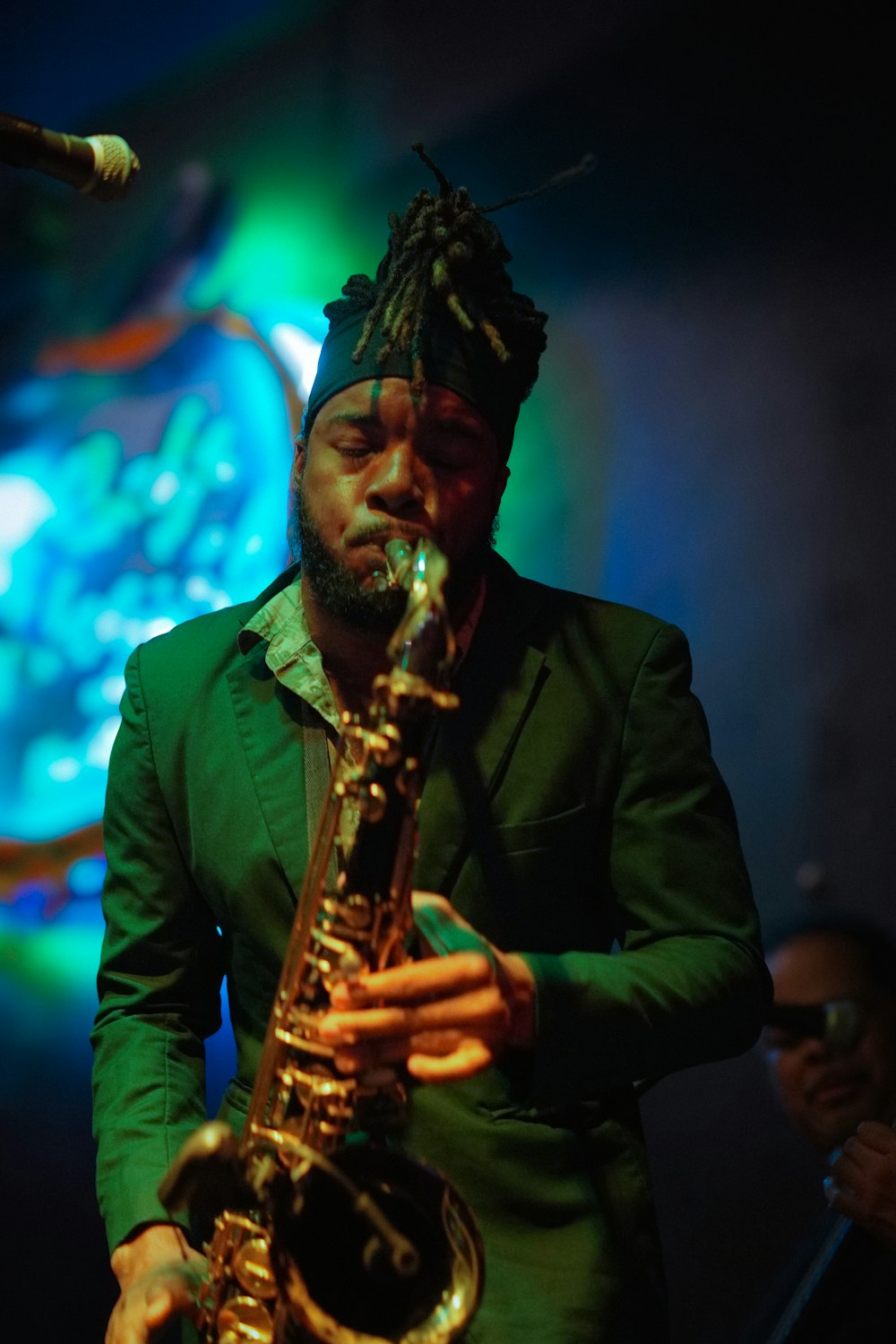 a man with dreadlocks playing a saxophone