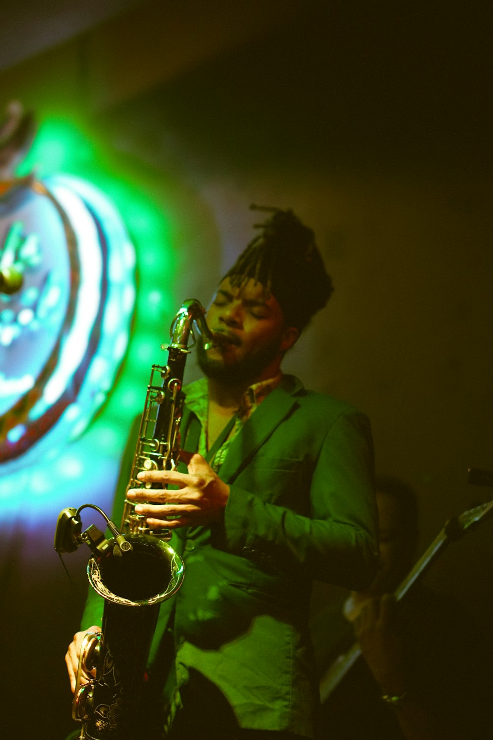 a man in a green suit playing a saxophone