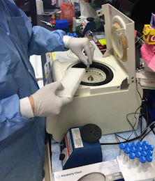 a person in a lab coat and gloves