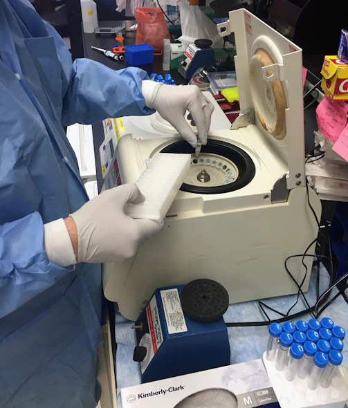 a person in a lab coat and gloves