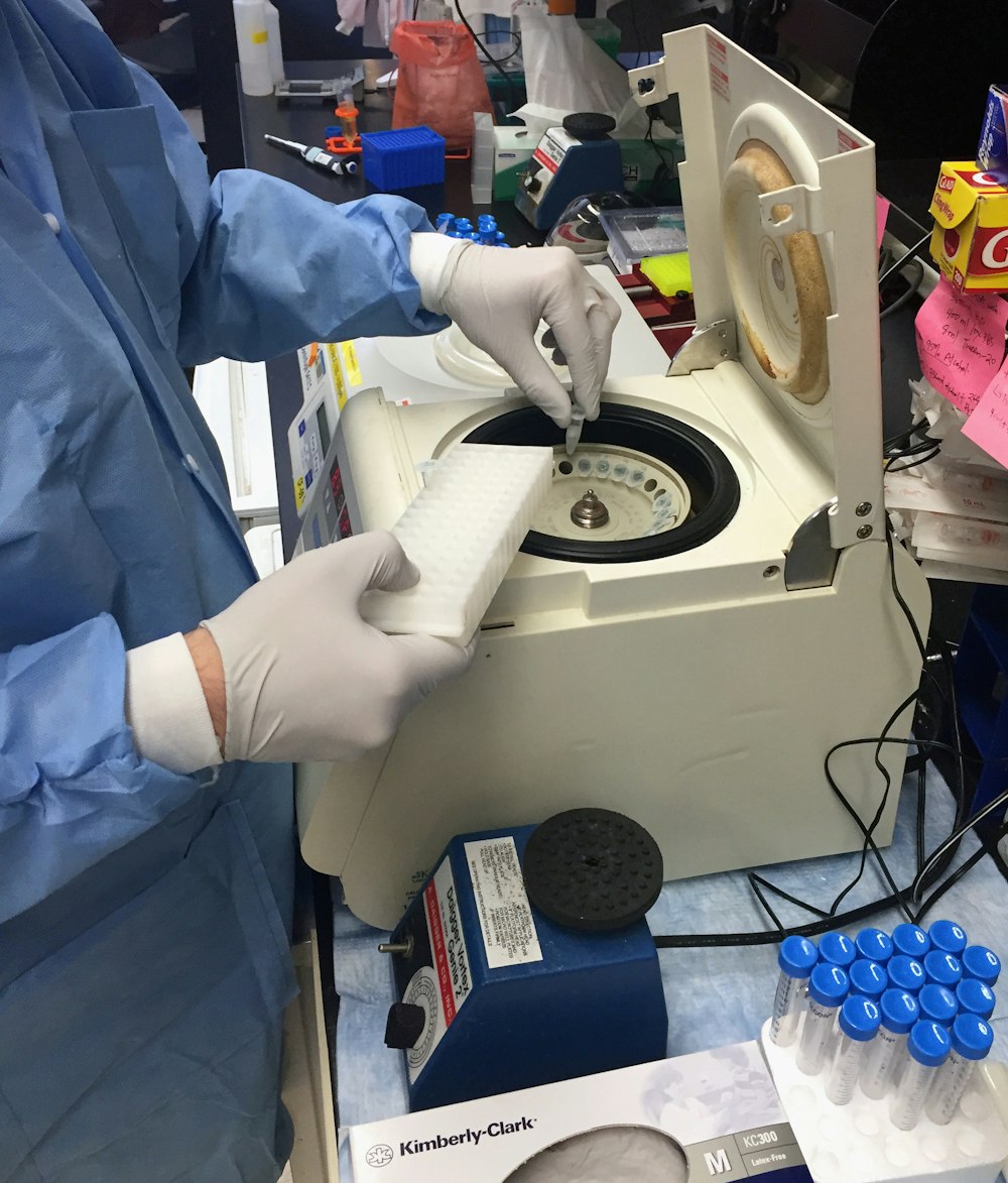 a person in a lab coat and gloves