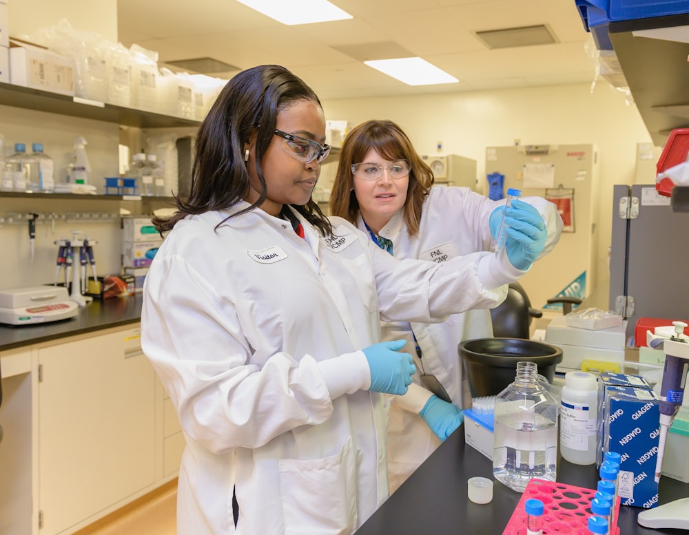 two women in lab coats working in a lab