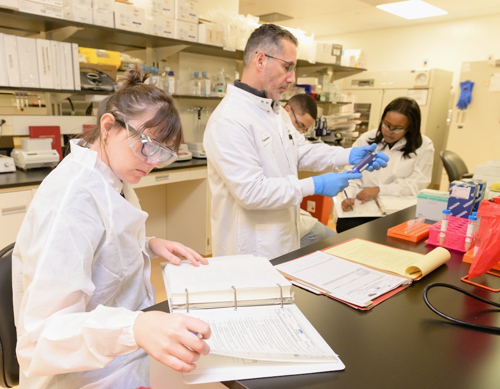a group of people in lab coats working in a lab
