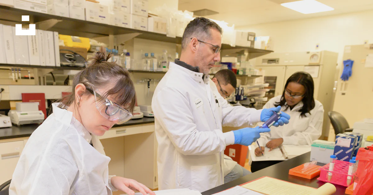 A group of people in lab coats working in a lab photo – Free Research ...
