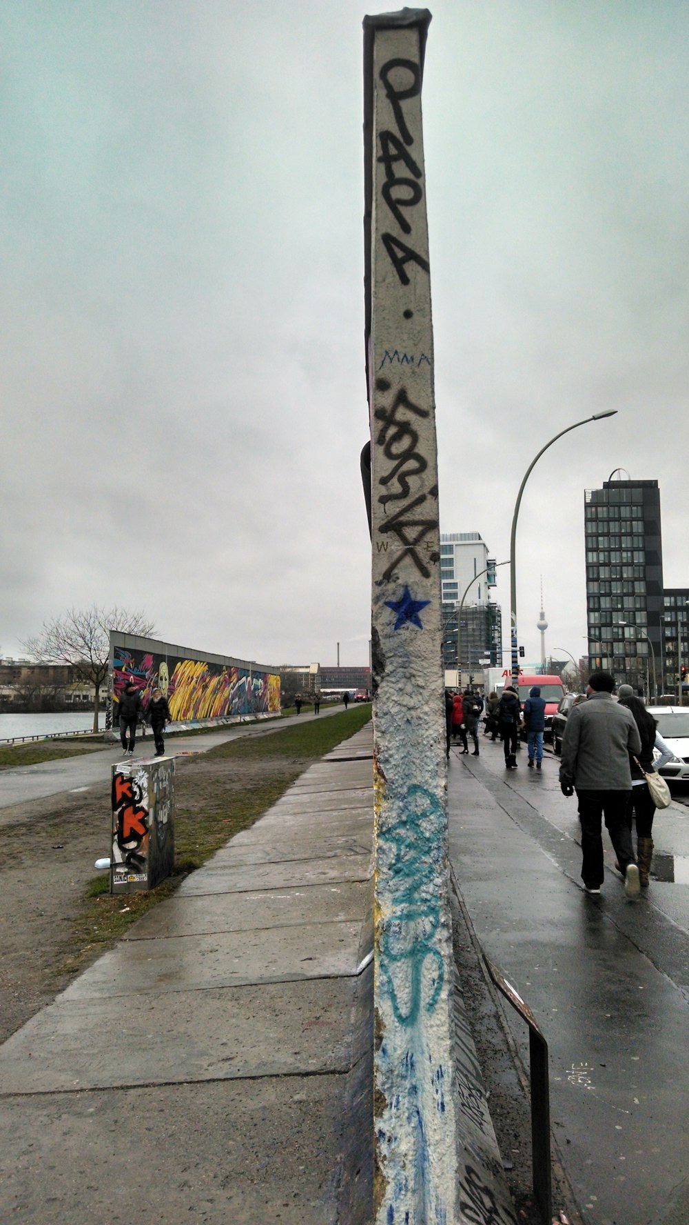 a pole with graffiti on it on a sidewalk