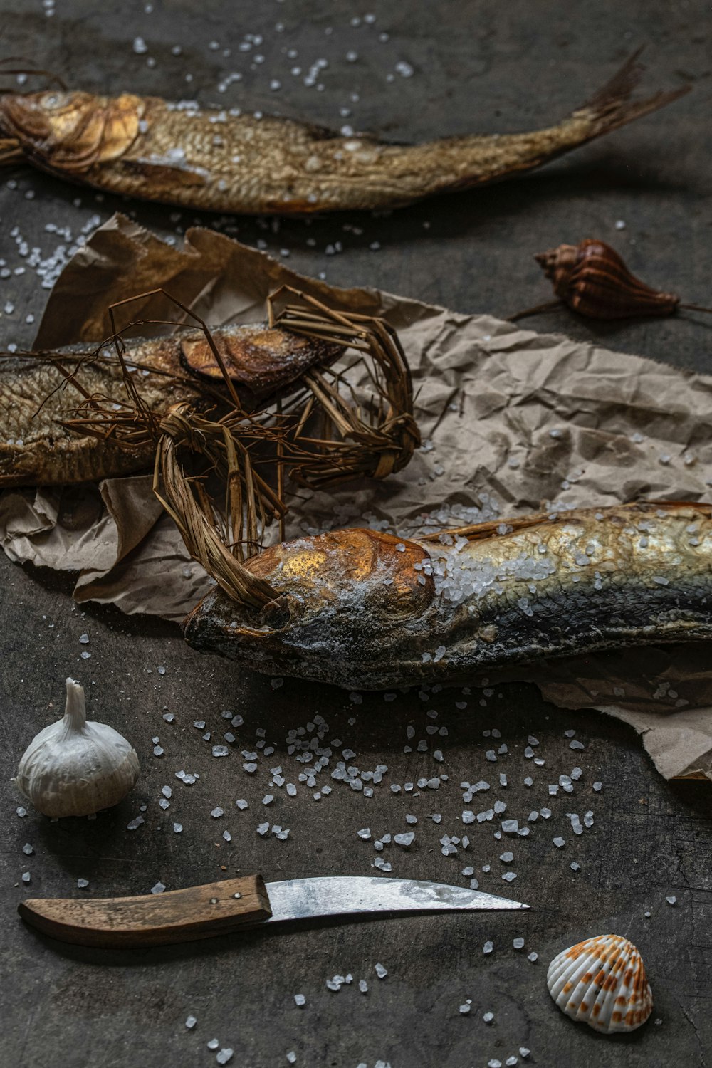 a piece of fish sitting on top of a table next to a knife