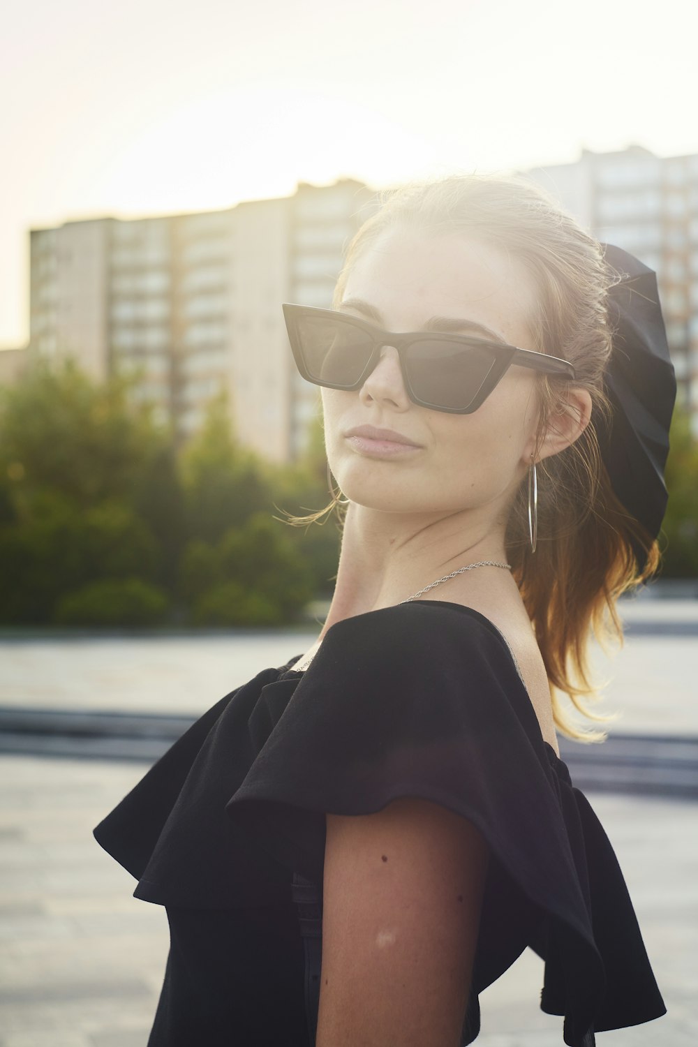 a woman wearing sunglasses and a black dress