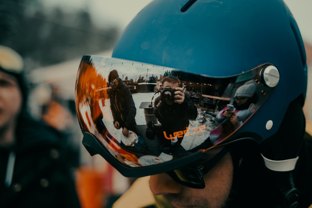 a man wearing a helmet with a reflection of himself in it
