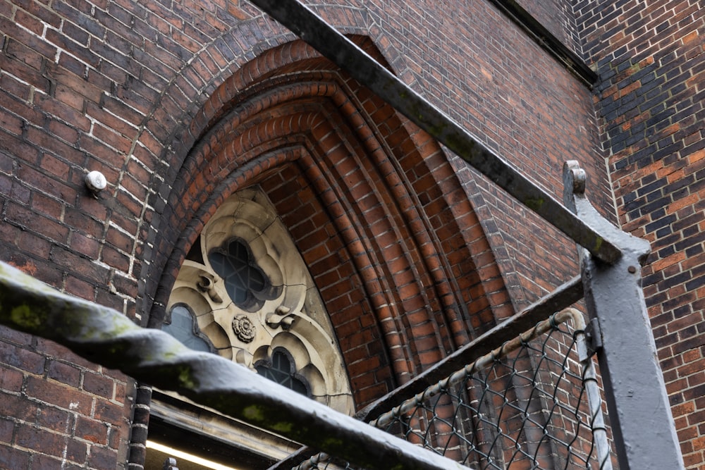 a close up of a metal railing near a brick building