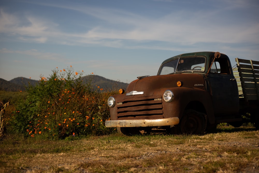 an old truck is parked in a field