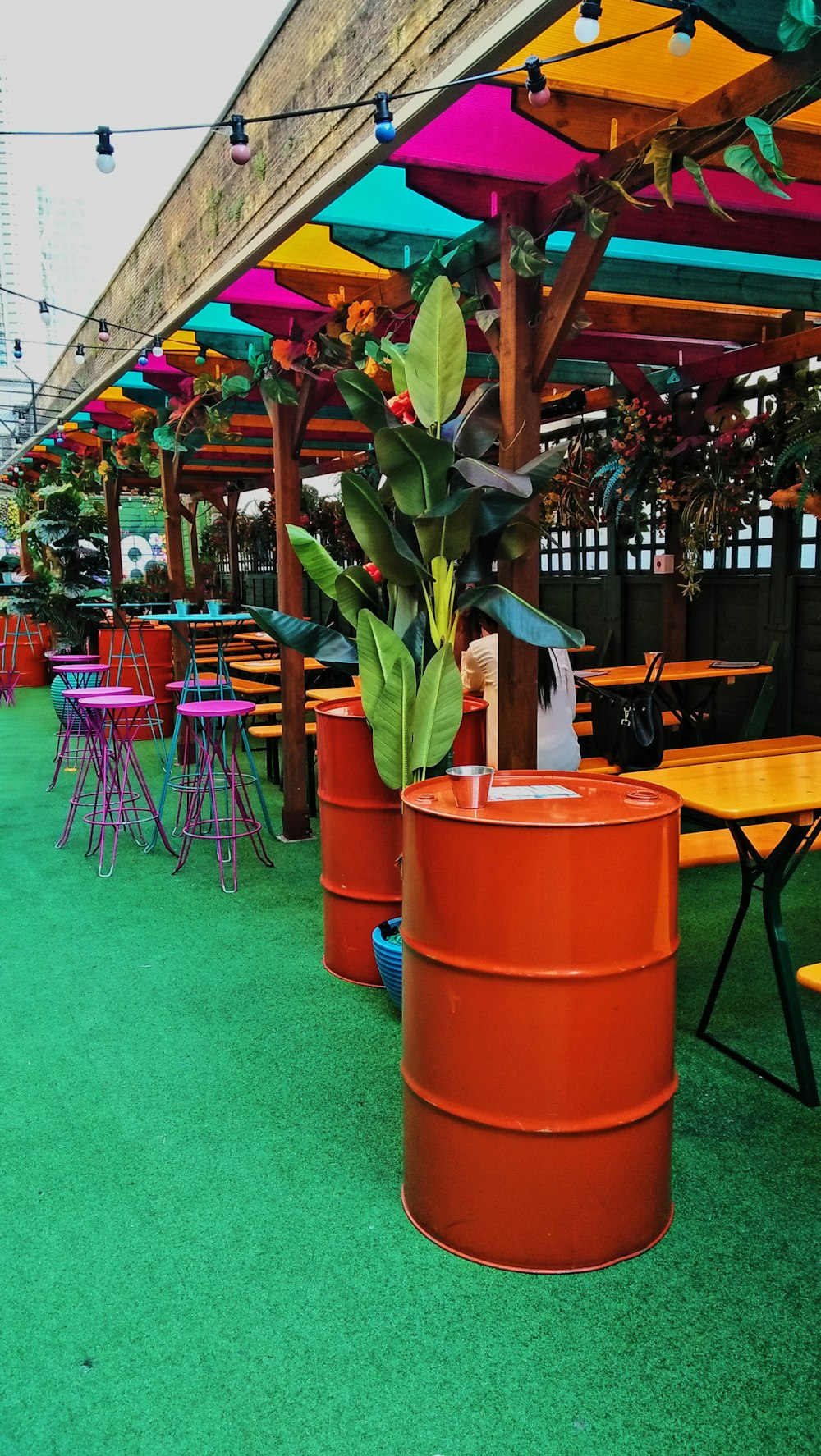 a row of colorful tables with umbrellas over them