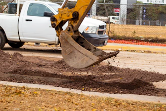 a white truck parked next to a pile of dirt