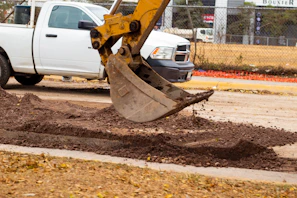 a white truck parked next to a pile of dirt