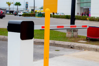 a yellow and white barrier sitting on the side of a road