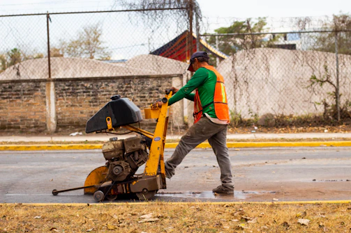 a man in a safety vest is working on a street