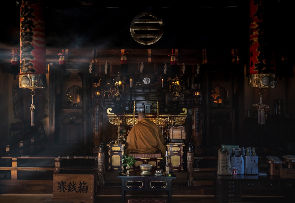 um monge sentado em um trono em uma sala