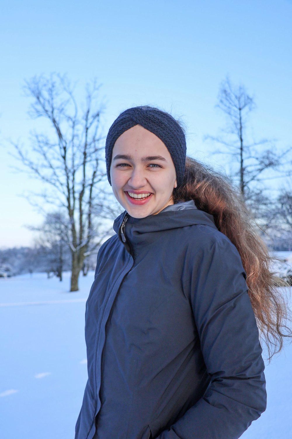 a woman in a blue jacket is standing in the snow