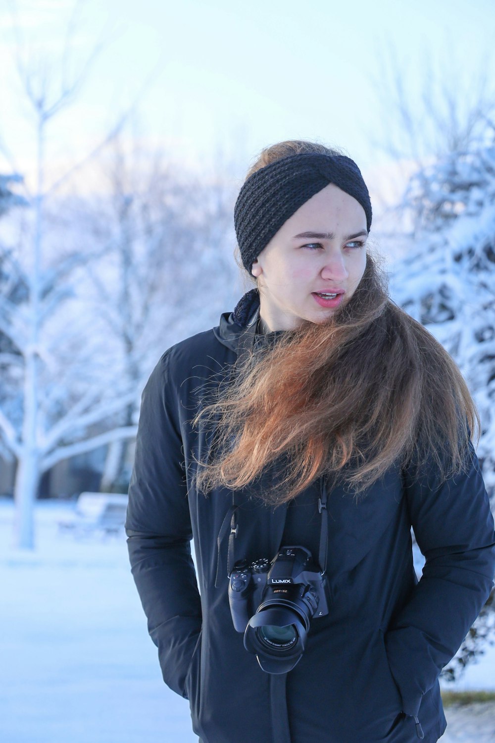 a woman standing in the snow with a camera