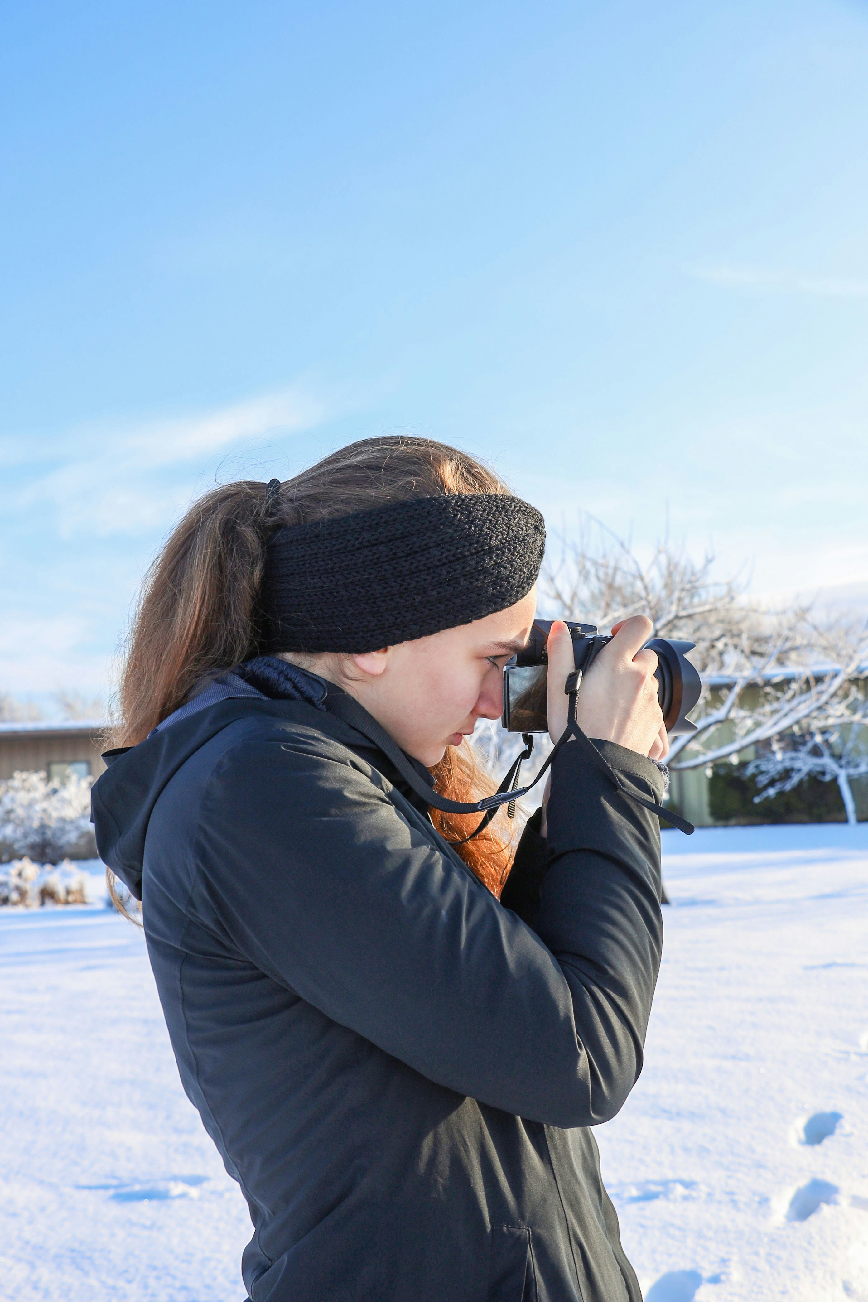 una mujer tomando una foto con una cámara en la nieve