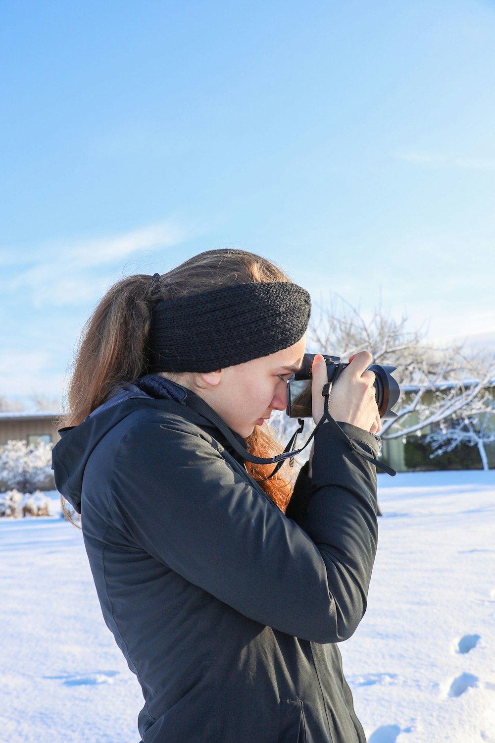 a woman taking a picture with a camera in the snow