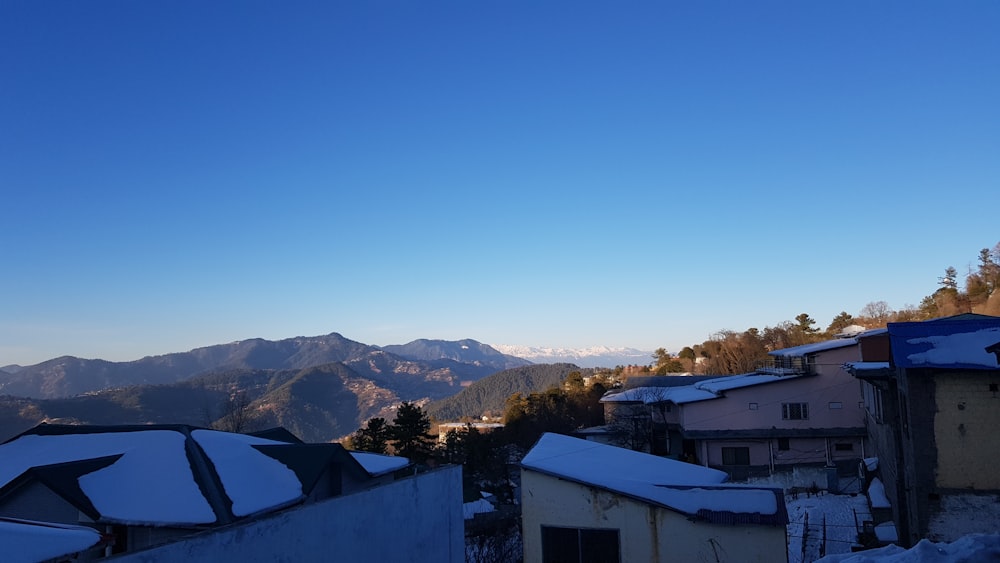 a view of a snowy mountain range from a rooftop