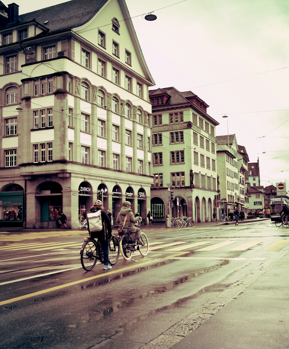 a man riding a bike down a street next to tall buildings