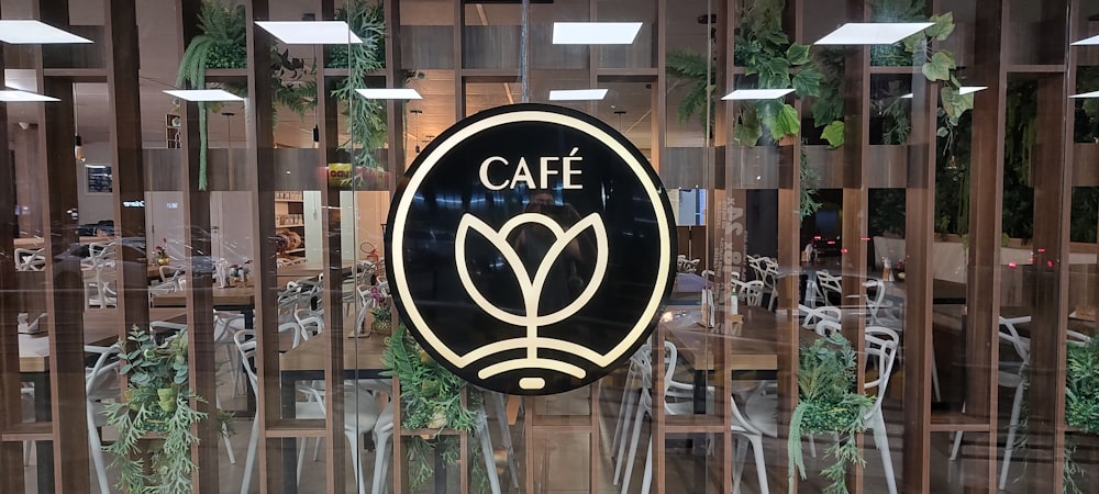 a cafe sign hanging from the side of a building