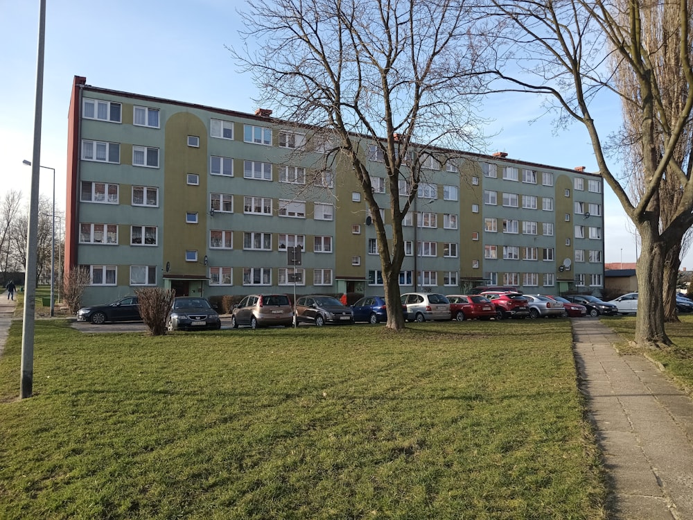 an apartment building with cars parked in front of it