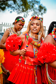 a group of women in red dresses standing next to each other