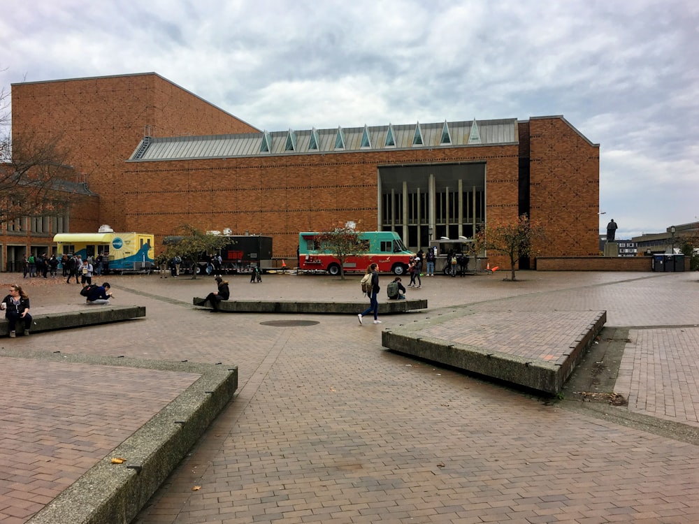 a group of people sitting on benches in front of a building