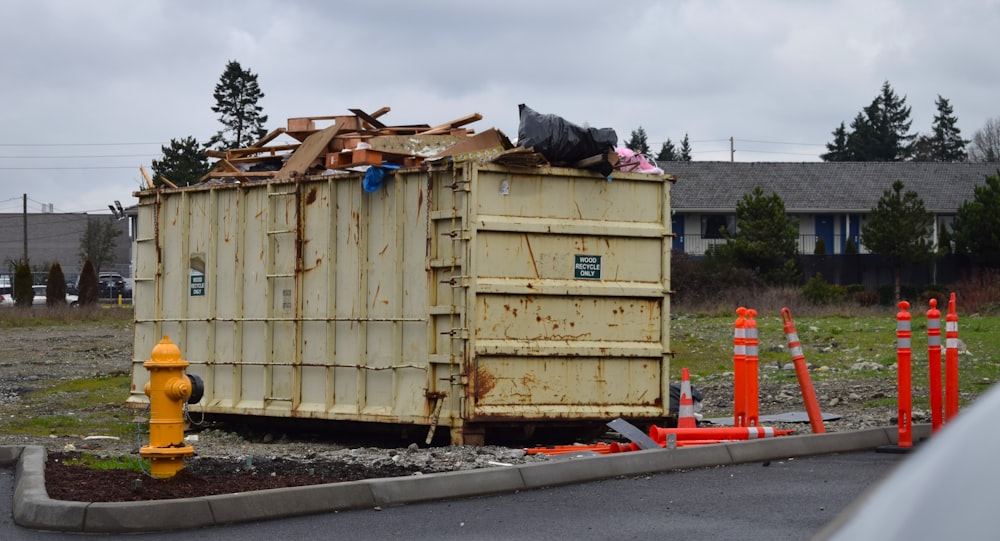 a dumpster sitting on the side of a road next to a fire hydrant