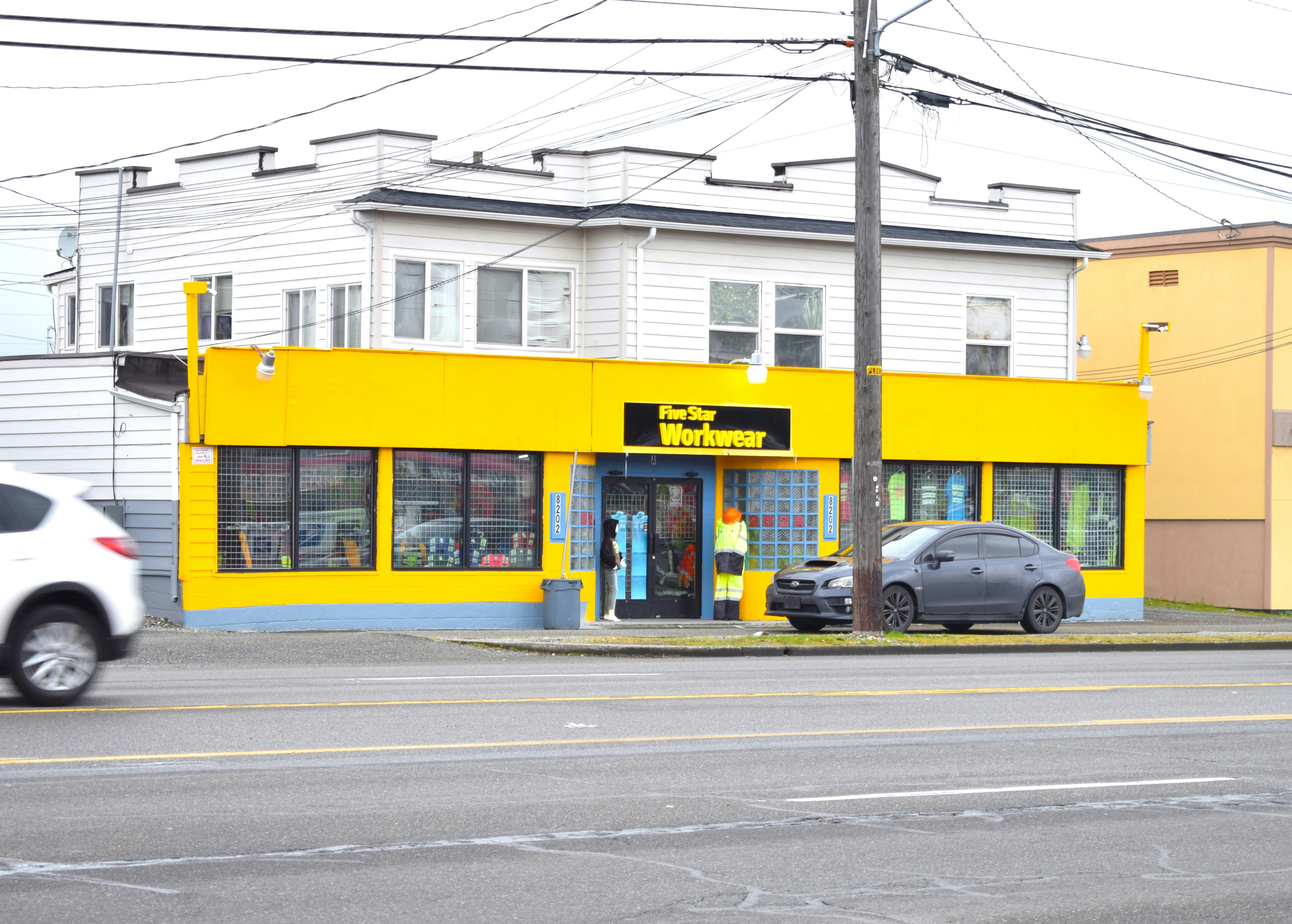 a yellow building with two cars parked in front of it