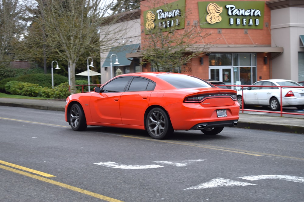 a red car is parked in front of a store