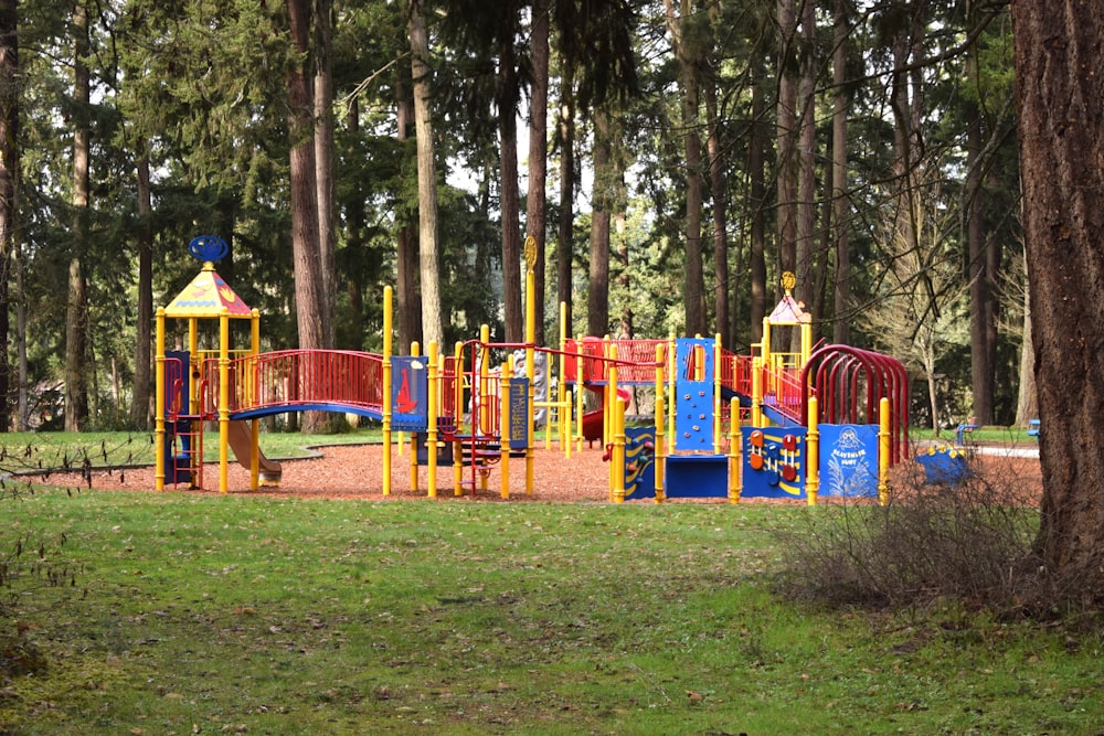 a colorful playground in a park surrounded by trees