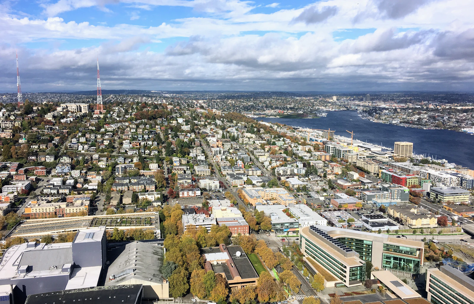 Aerial view over Queen Anne hill and the ship canal with dense Seattle residential blocks stretching to the water