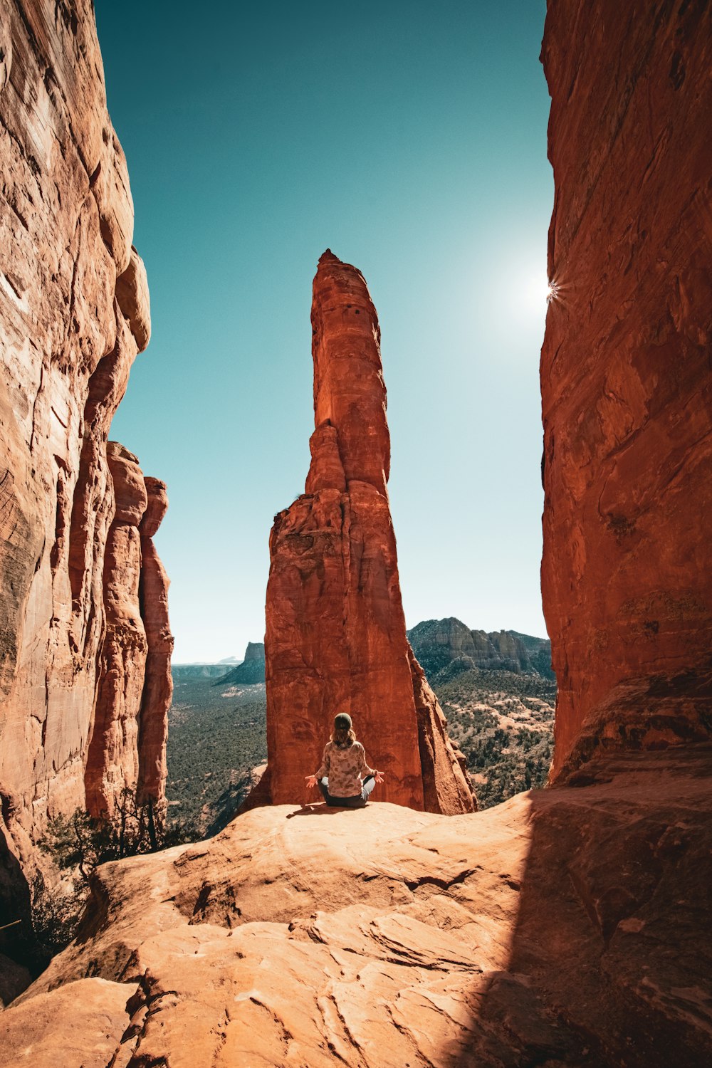 a person sitting on a rock in the desert