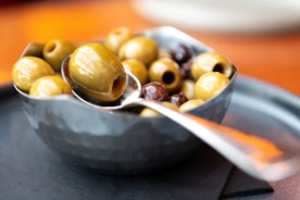 a spoon full of olives on a plate