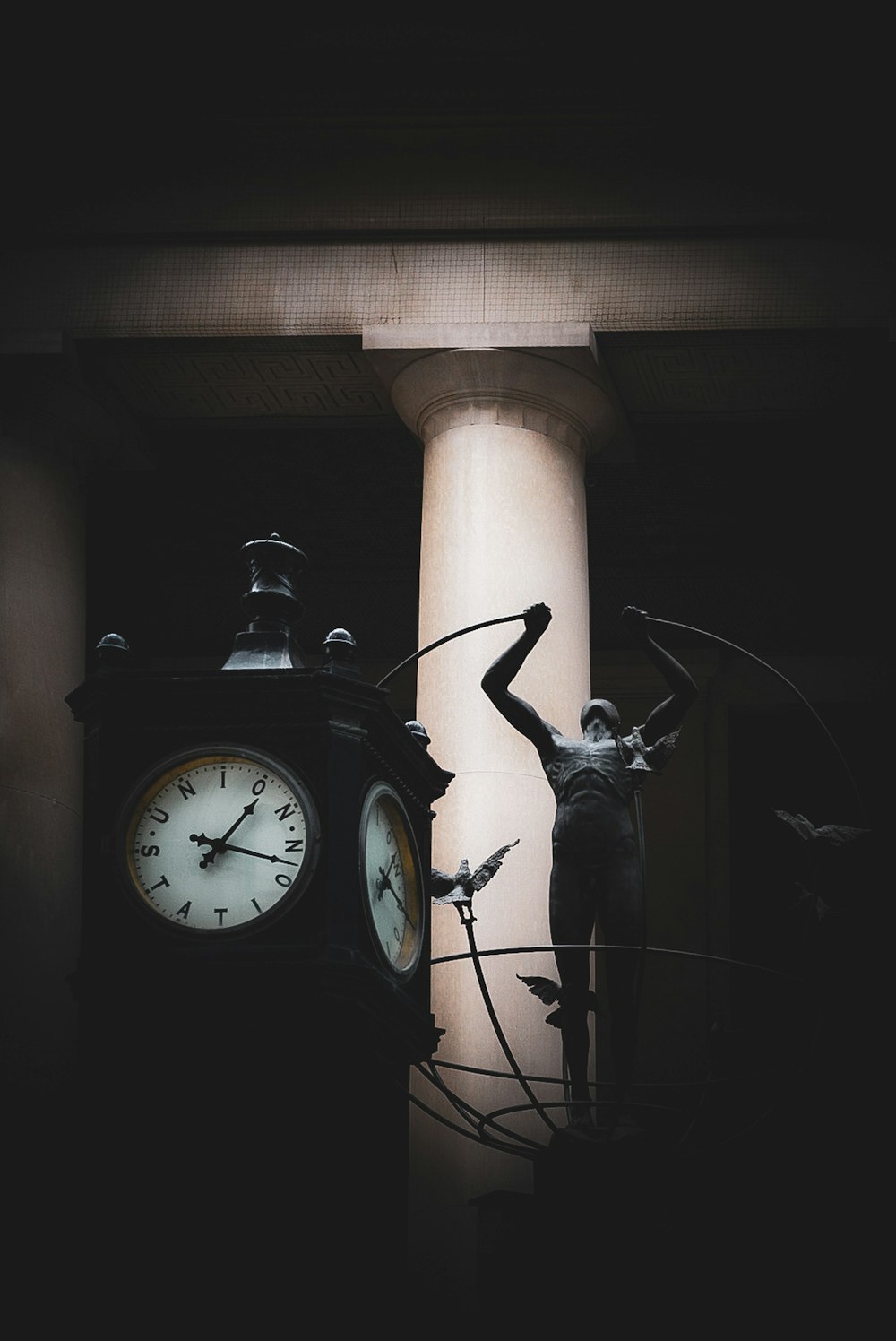 a statue of a man standing next to a clock