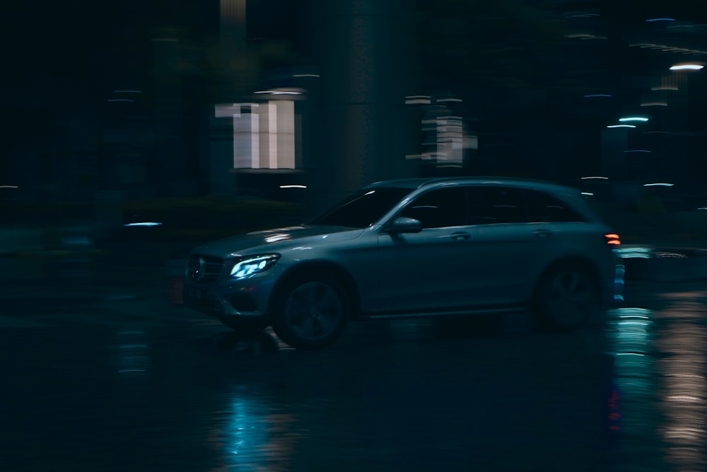 a car driving down a street at night