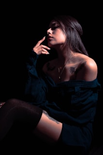 a woman in a black dress smoking a cigarette