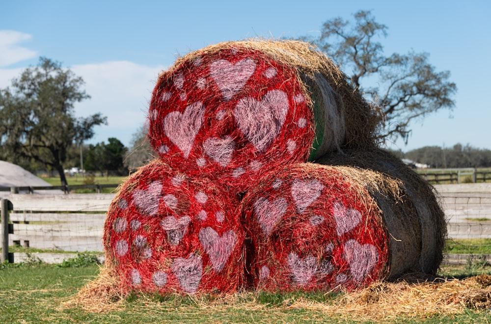 a pile of hay sitting on top of a lush green field