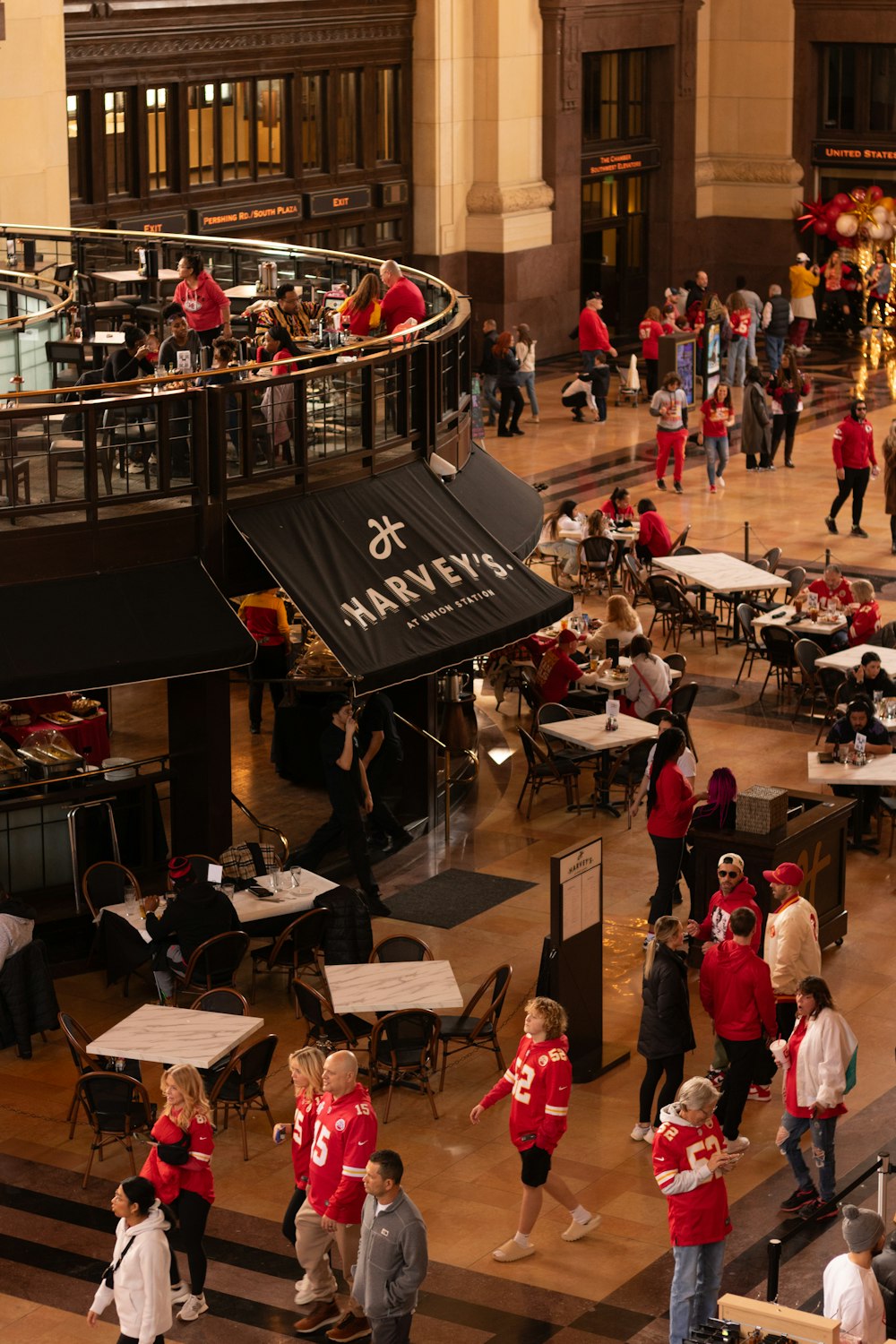 a group of people standing around tables in a building