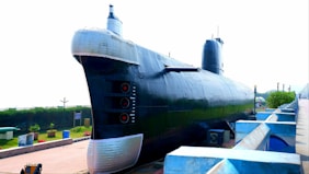 a large black submarine sitting on top of a sidewalk